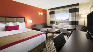 Une chambre d’hôtel avec un lit, un canapé, un bureau et une télévision.