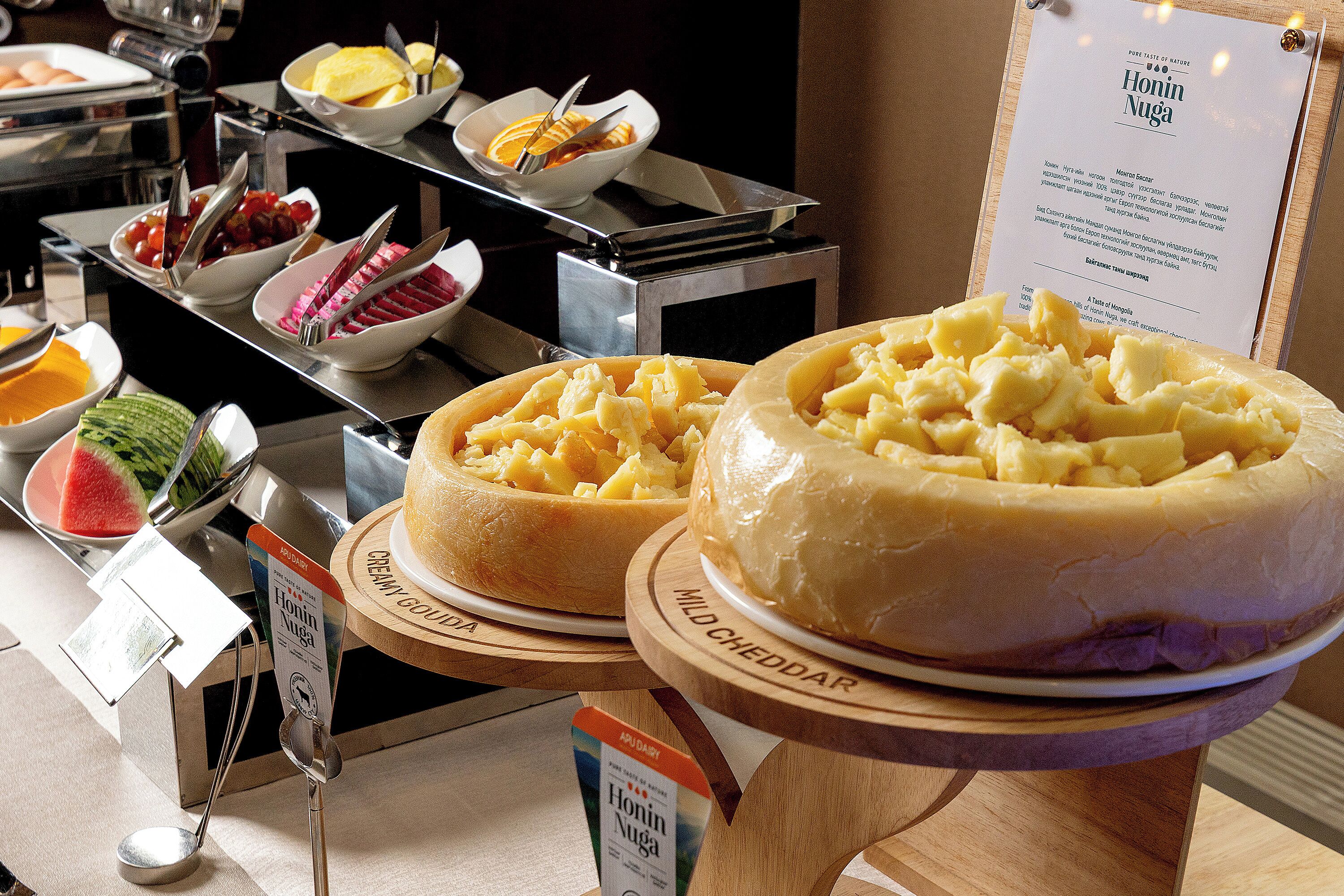 A buffet with various food items including a large bowl of mashed potatoes and a sign indicating 'Creamy Gold' and 'Mild Cheddar' flavors.