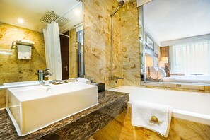 Een aparte badkuip en douche, een regendouche, gratis toiletartikelen