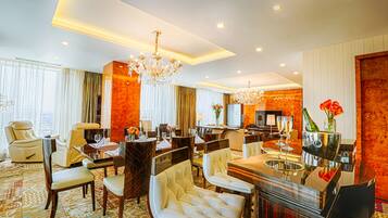A hotel lobby with a chandelier, seating area, and a television.