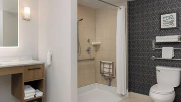 A modern bathroom with a shower, toilet, and sink.