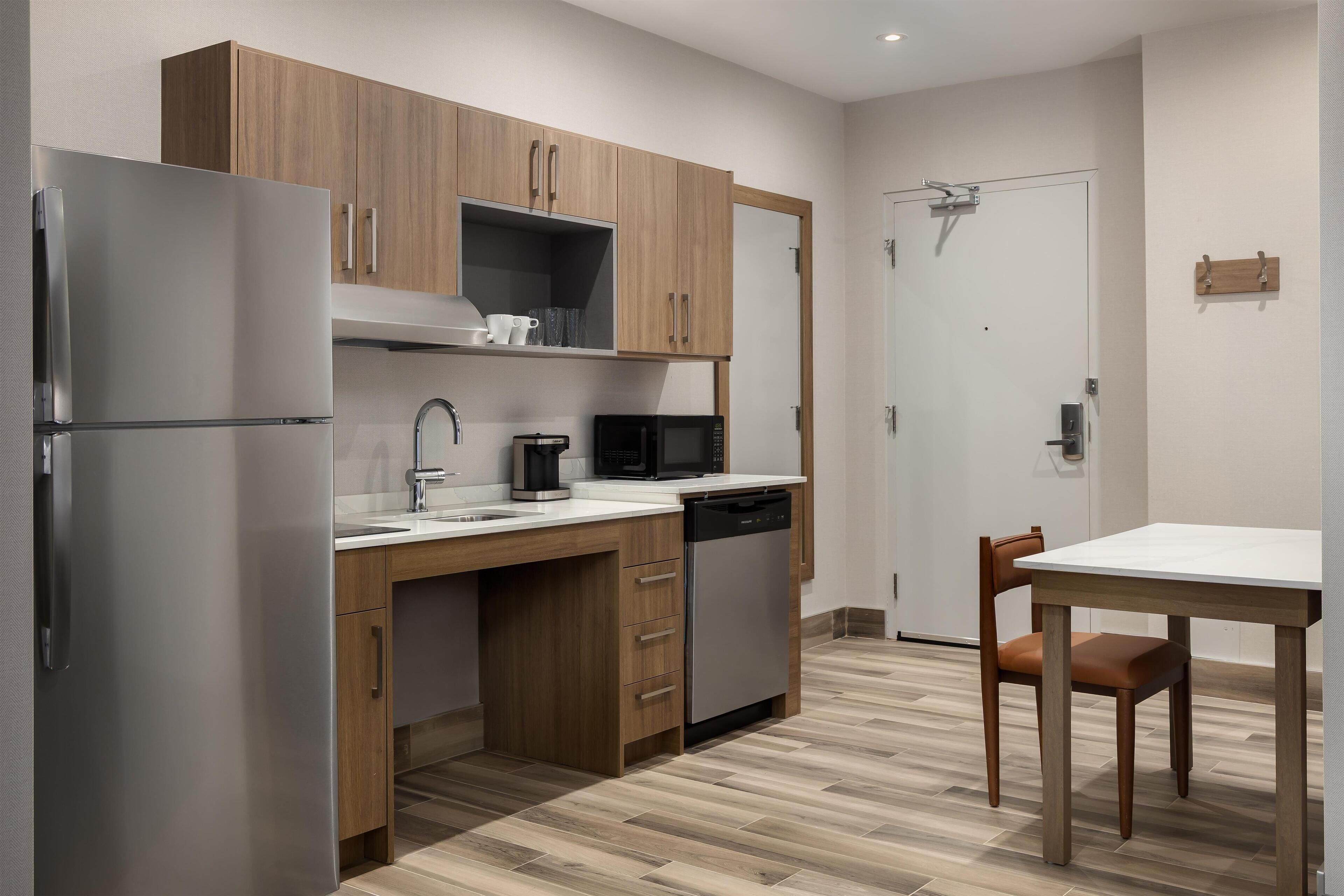 Una cocina moderna con armarios de madera, electrodomésticos de acero inoxidable y encimera blanca.