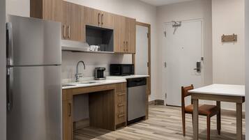 Una cocina moderna con armarios de madera, electrodomésticos de acero inoxidable y encimera blanca.