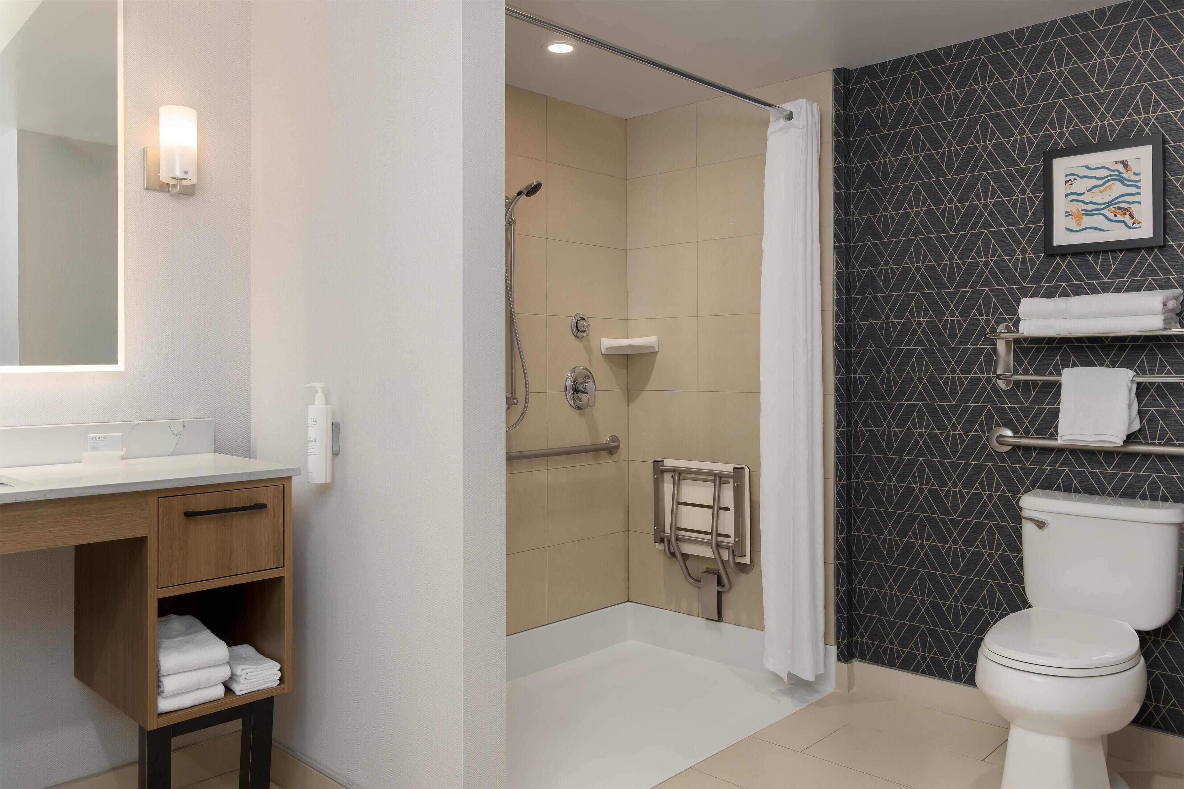 Une salle de bain moderne équipée d’une douche, de toilettes et d’un lavabo.