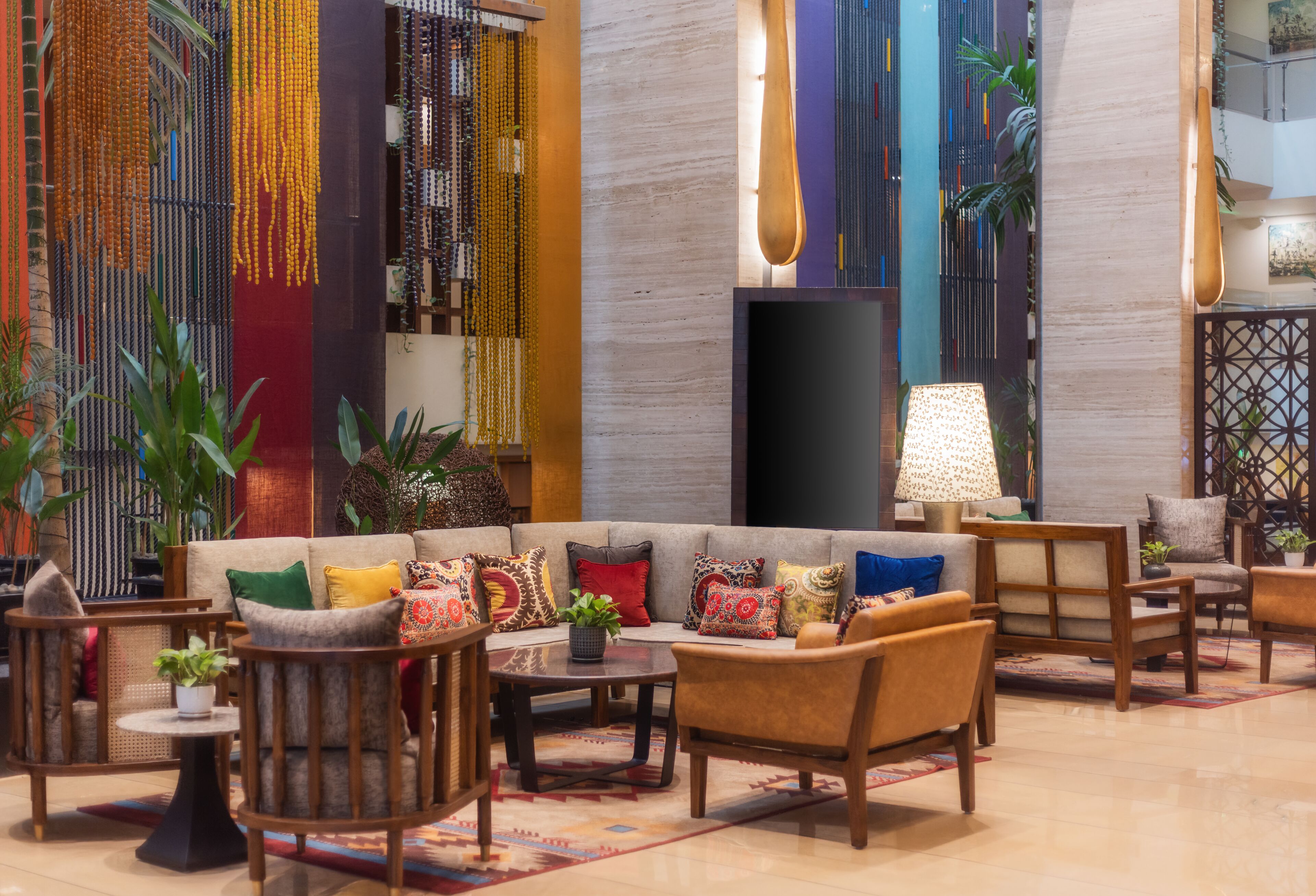 A lobby with a sofa, armchairs, a coffee table, and a TV.