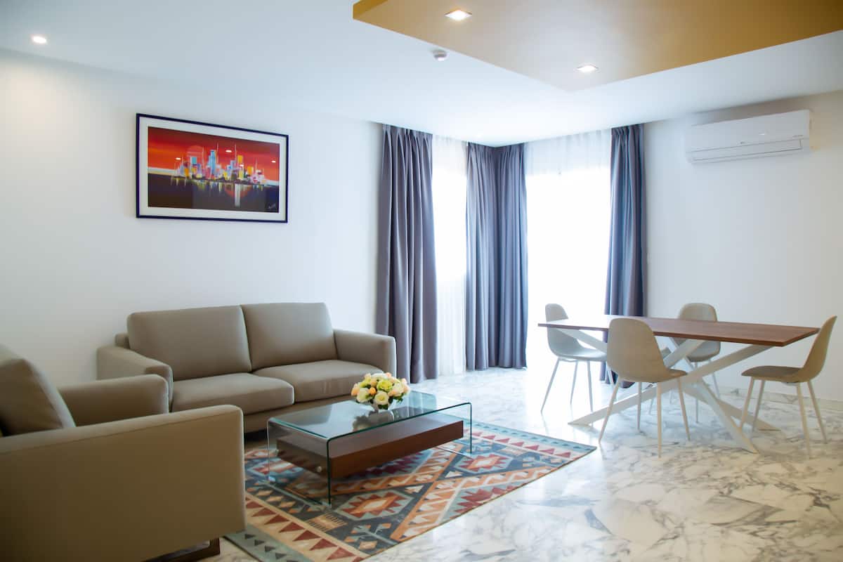 Una sala moderna con sofá, mesa de centro y comedor.