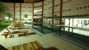 A hotel pool area with lounge chairs and a pool. - HITS PANTANAL HOTEL AEROPORTO (Varzea Grande)