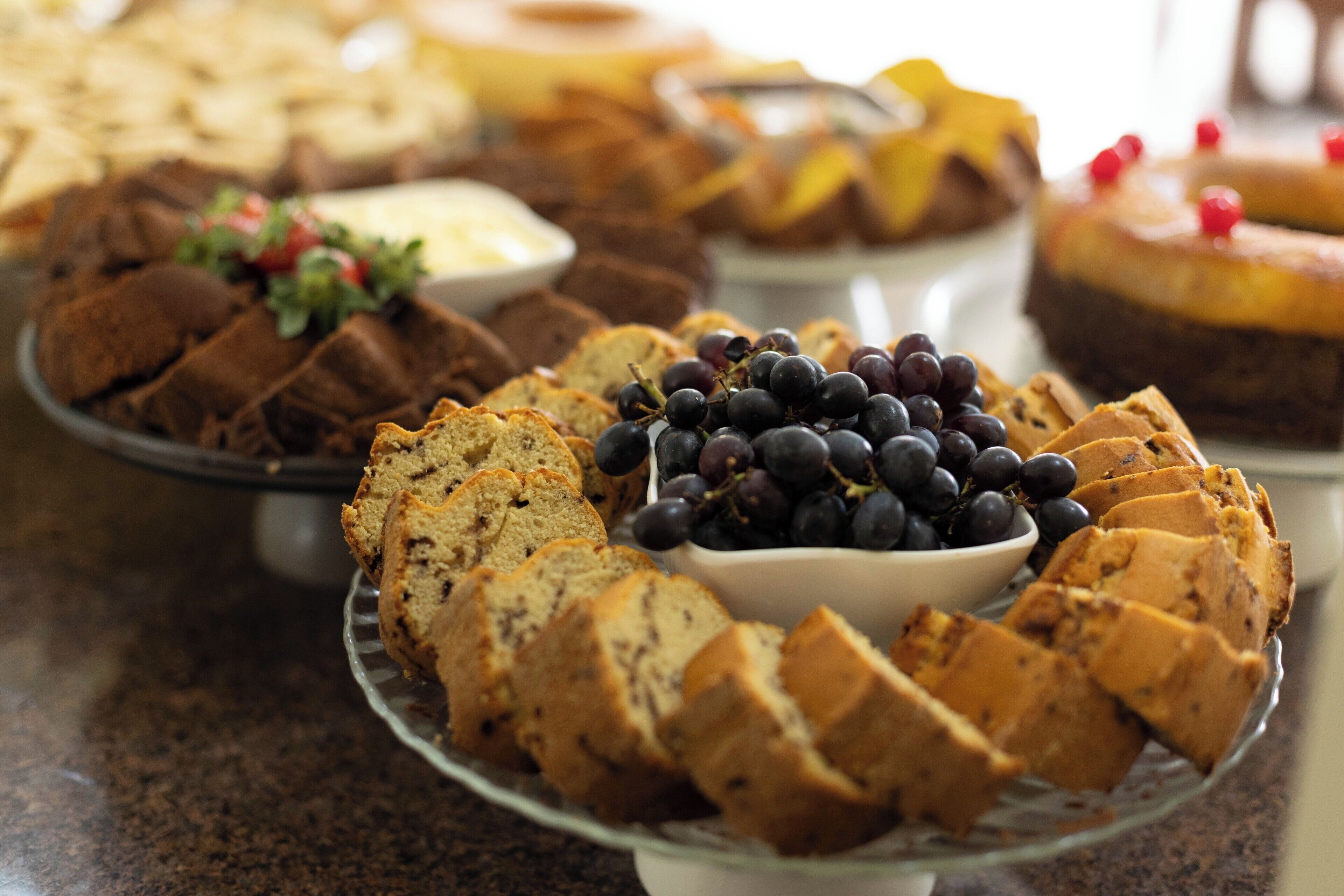 Variedad de productos horneados, incluyendo pan y muffins, sobre un plato de vidrio.