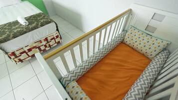 Cozy child's bedroom with a crib and a single bed, perfect for a family stay.