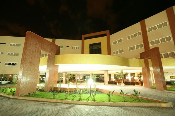 A hotel with a central courtyard, multiple floors, and a well-lit entrance. - HITS PANTANAL HOTEL AEROPORTO (Varzea Grande)
