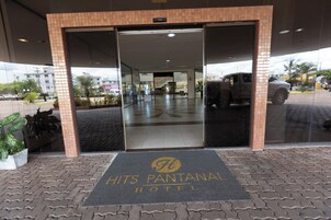 La entrada al Hotel Hits Pantanal, con una vista despejada del interior y el reflejo del entorno exterior.