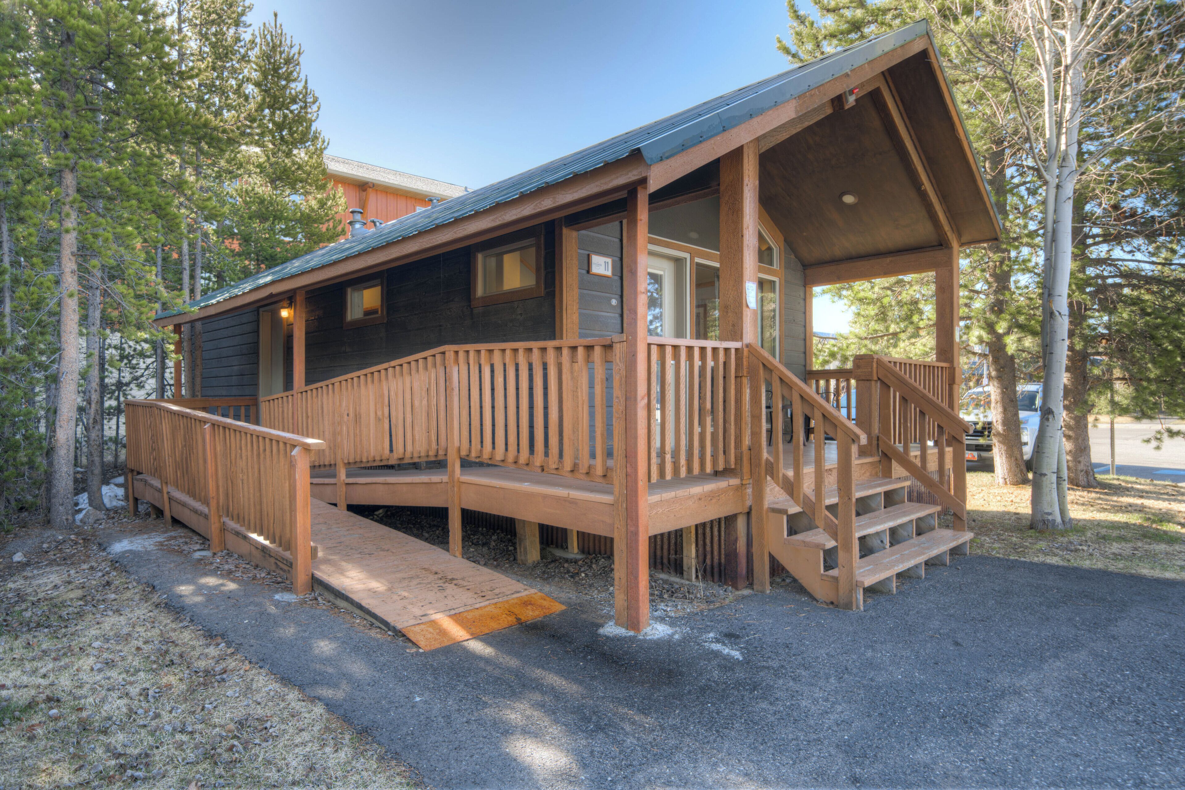 Une cabane en bois dotée d’un porche et d’une rampe d’accès pour faciliter la mobilité.