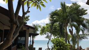 A pathway leading to a beach with palm trees and a clear view of the ocean. - Sunrise Bungalow (Koh Samui)