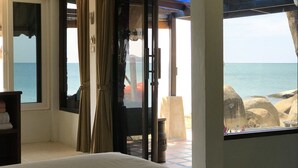 A room with a bed, a window with curtains, and a view of the sea. - Sunrise Bungalow (Koh Samui)