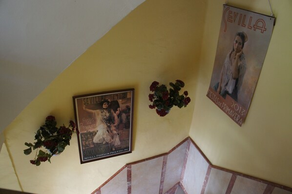 A wall with two posters, one depicting a historical scene and the other a person.