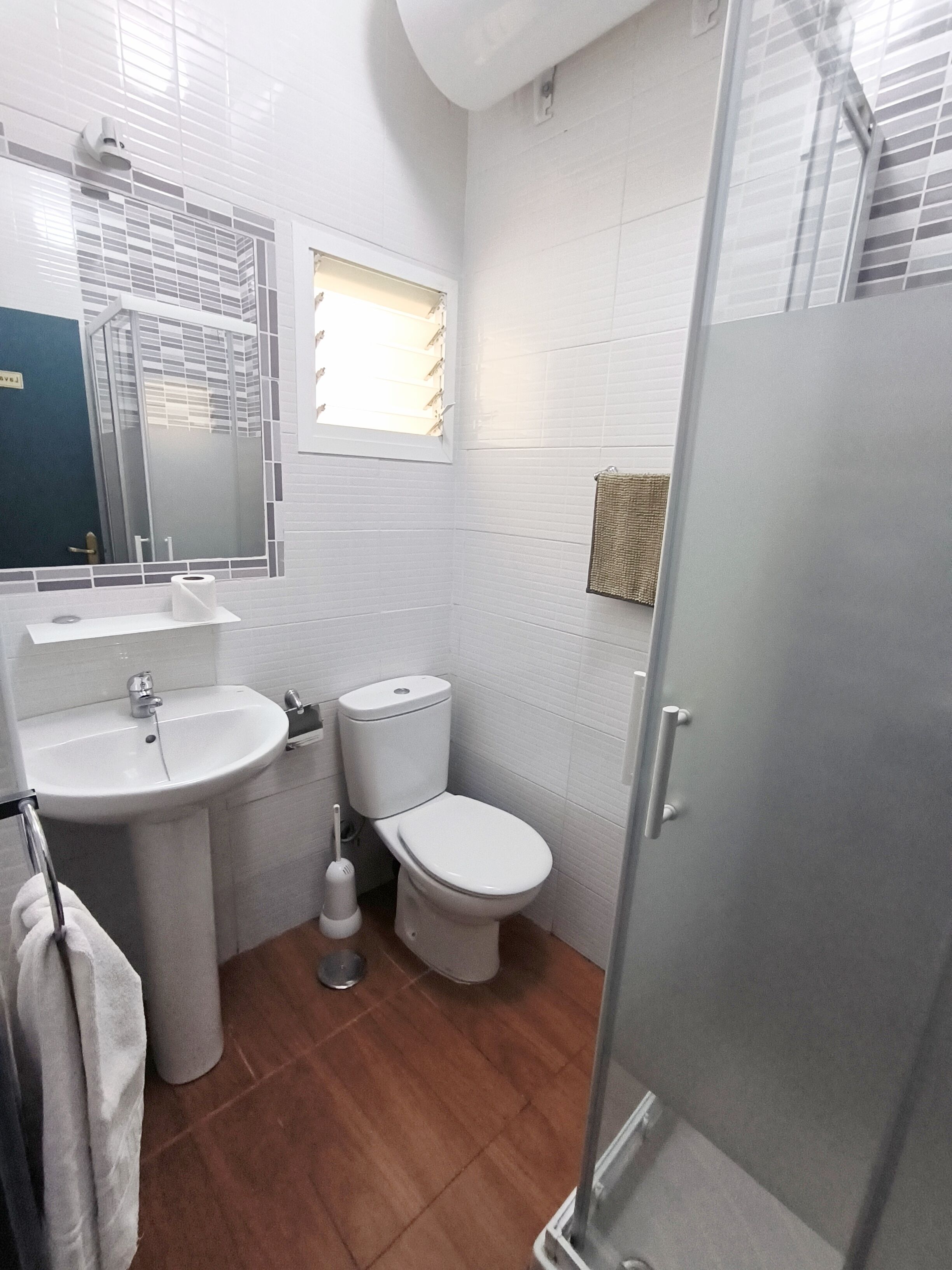 Un bagno con lavandino, WC e doccia.