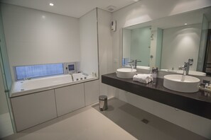 A modern bathroom with a large bathtub, two sinks, and a large mirror. - Salto Hotel & Casino (Salto)