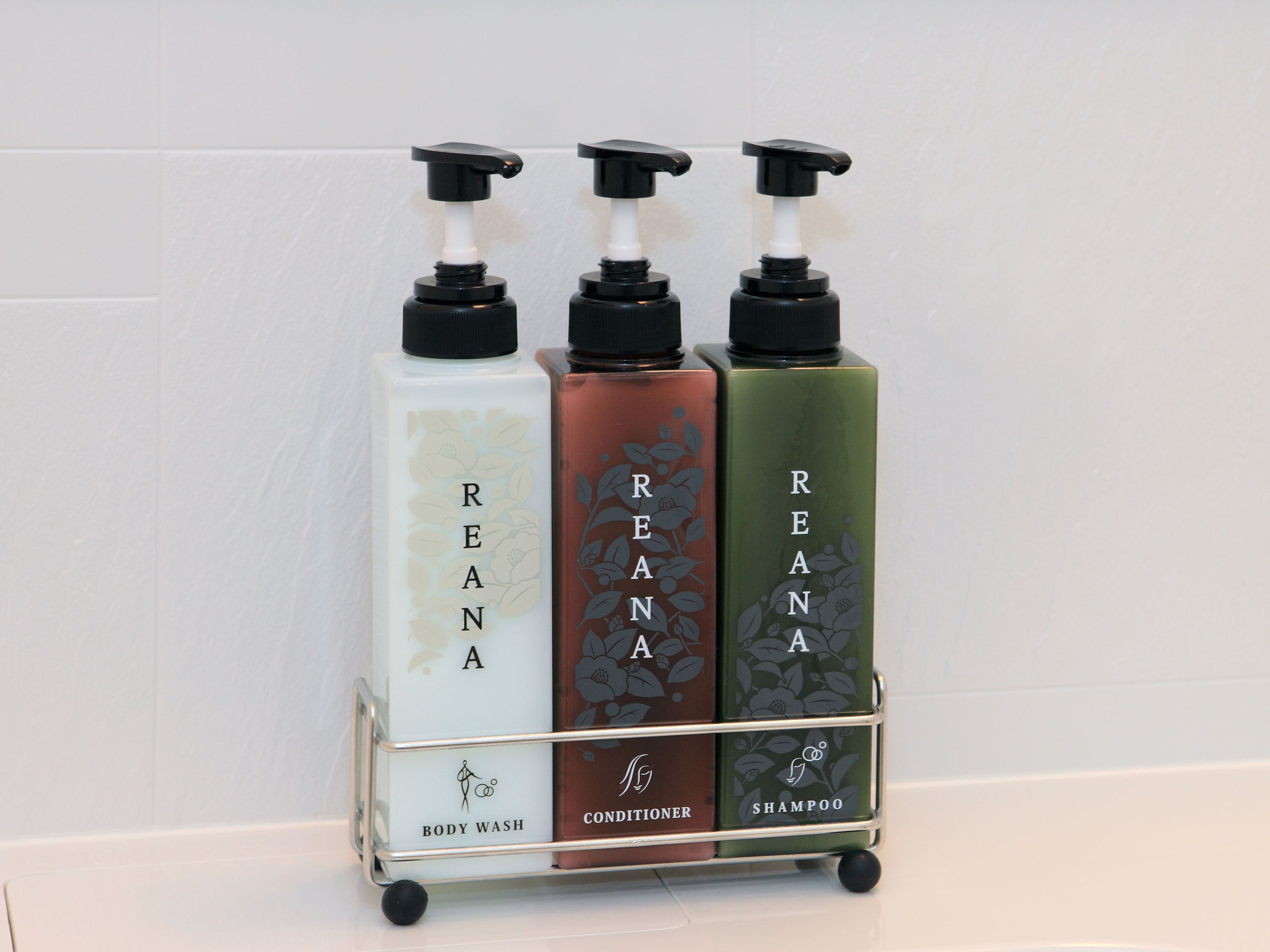 Ein Wägelchen mit drei Flaschen Reana Duschgel, Conditioner und Shampoo.