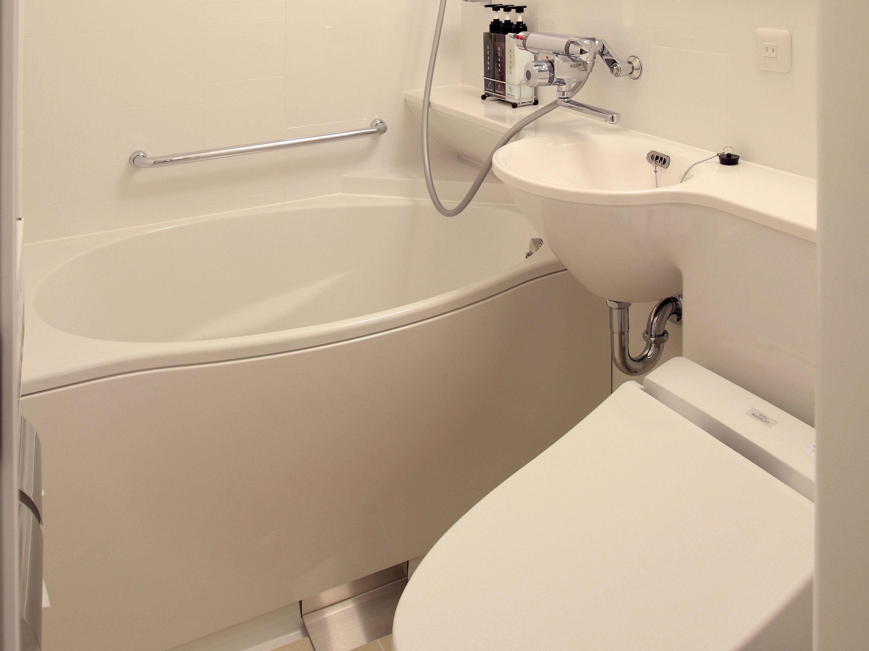 Et badeværelse med badekar, håndvask og toilet.