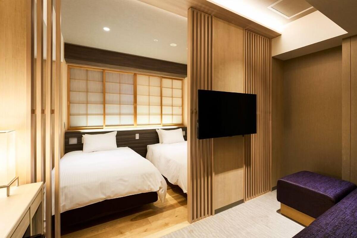 Ein Hotelzimmer mit Bett, Fernseher und einer Sitzecke.
