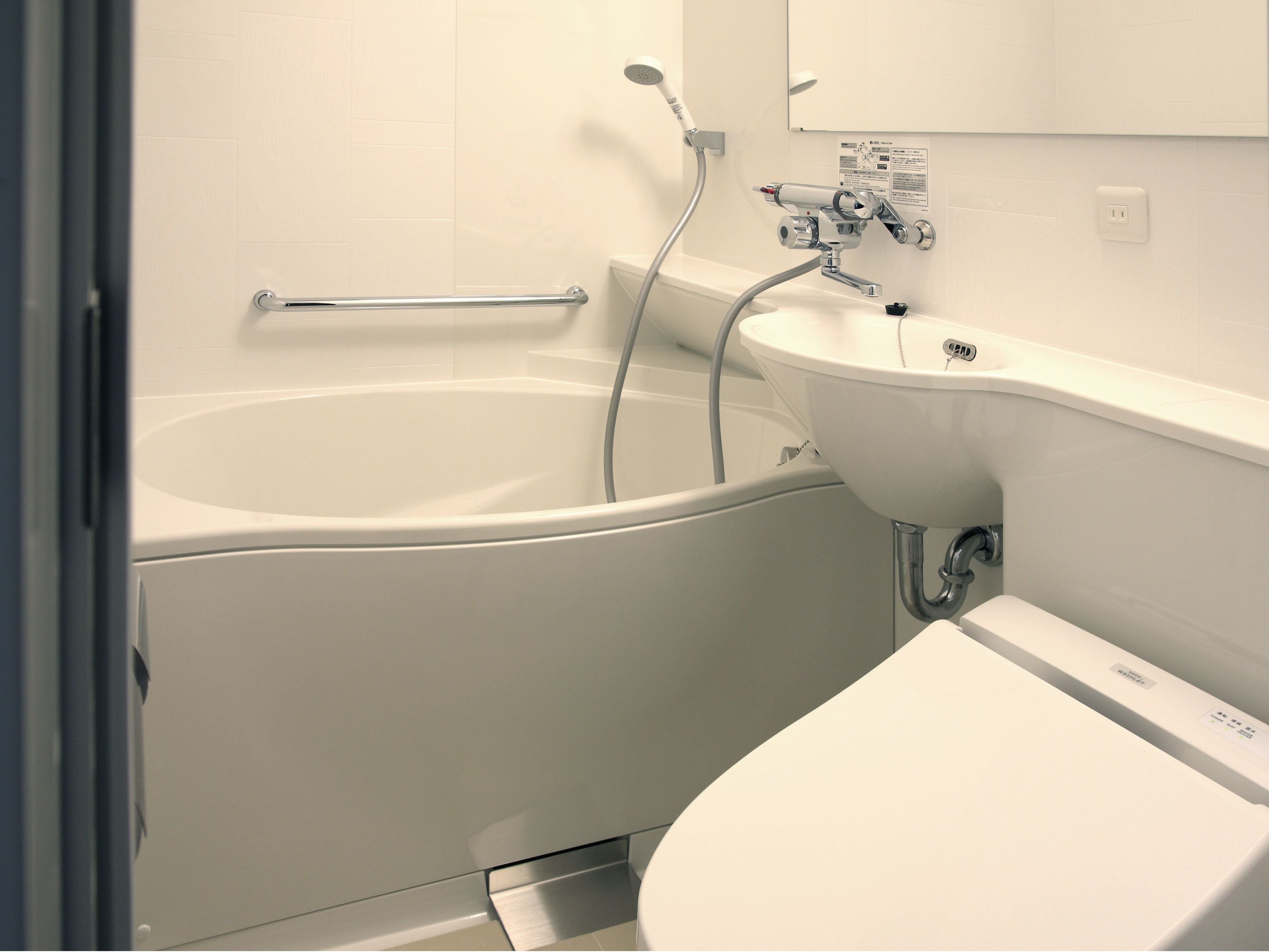 A modern bathroom with a bathtub, a sink, and a showerhead.