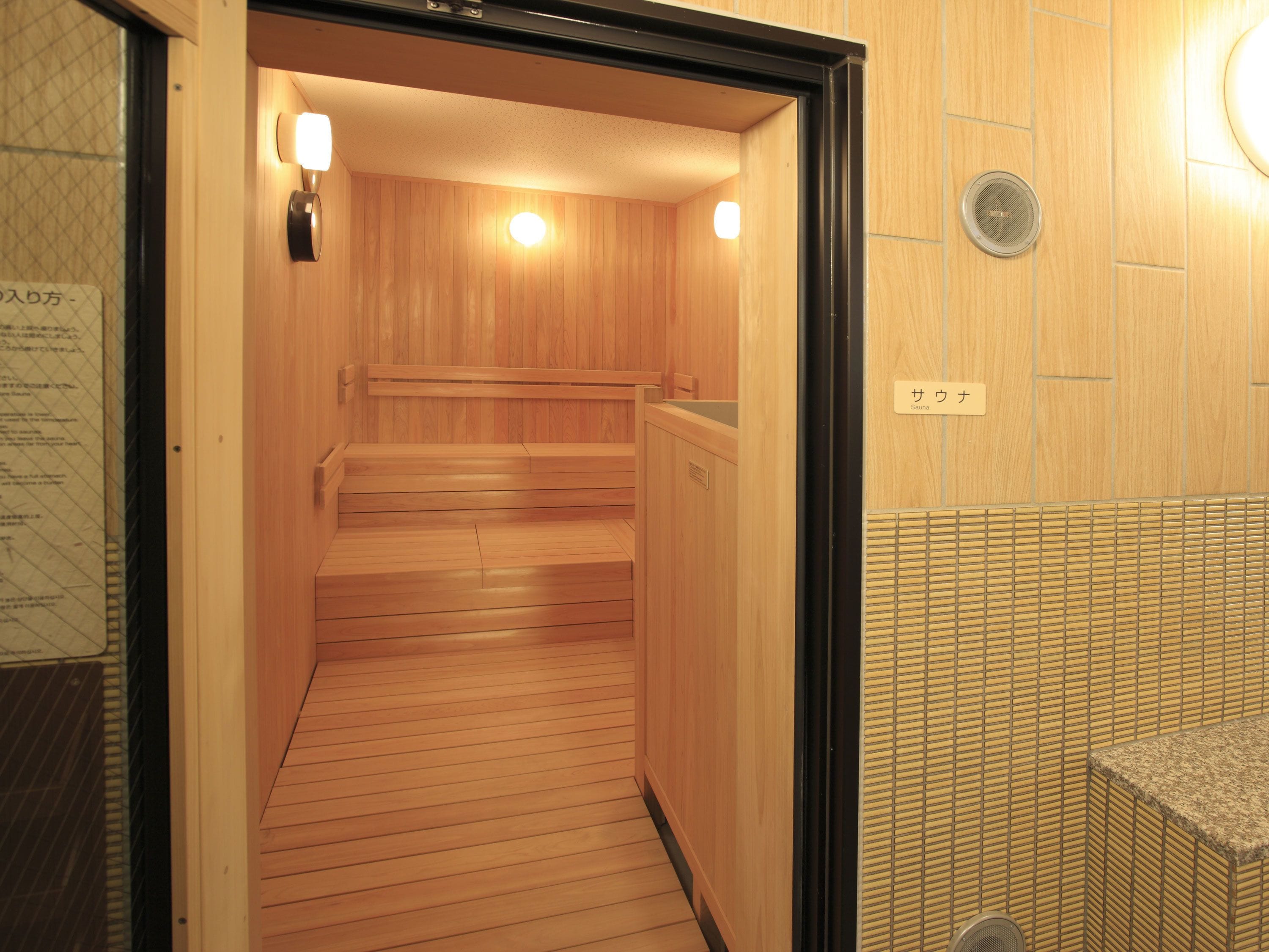 A sauna with wooden benches and a tiled wall.