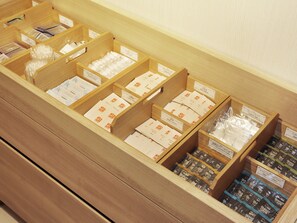 A wooden storage unit with compartments containing various toiletries and personal care items. - HOTEL ELCIENT KYOTO HACHIJOGUCHI (Kyoto)