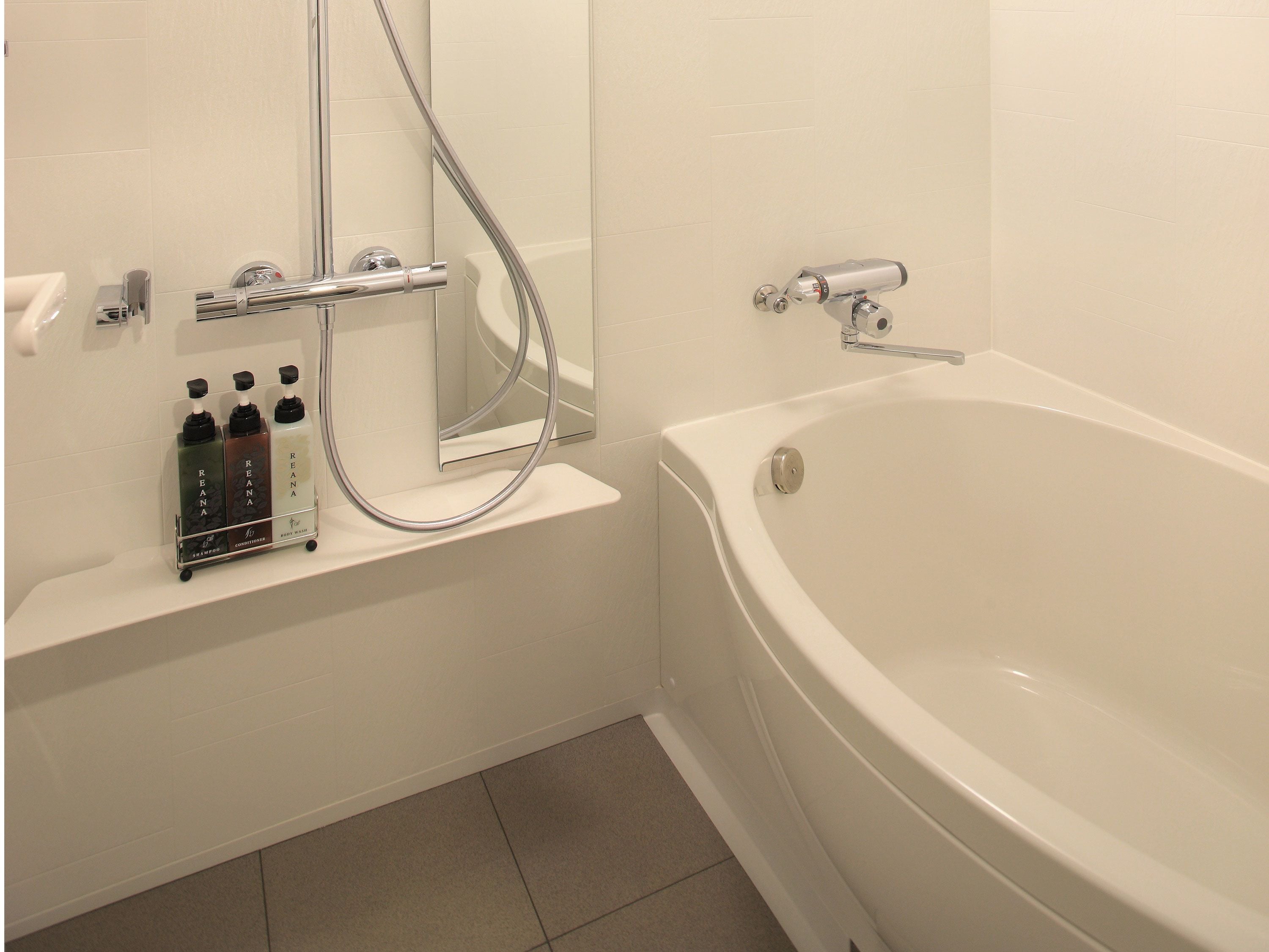A modern bathroom with a bathtub, a shower, and a vanity with toiletries.