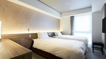 A hotel room with two beds, a desk, a TV, and a large window with curtains.
