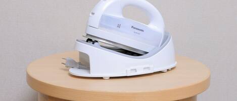 A white Panasonic iron on a small wooden table.