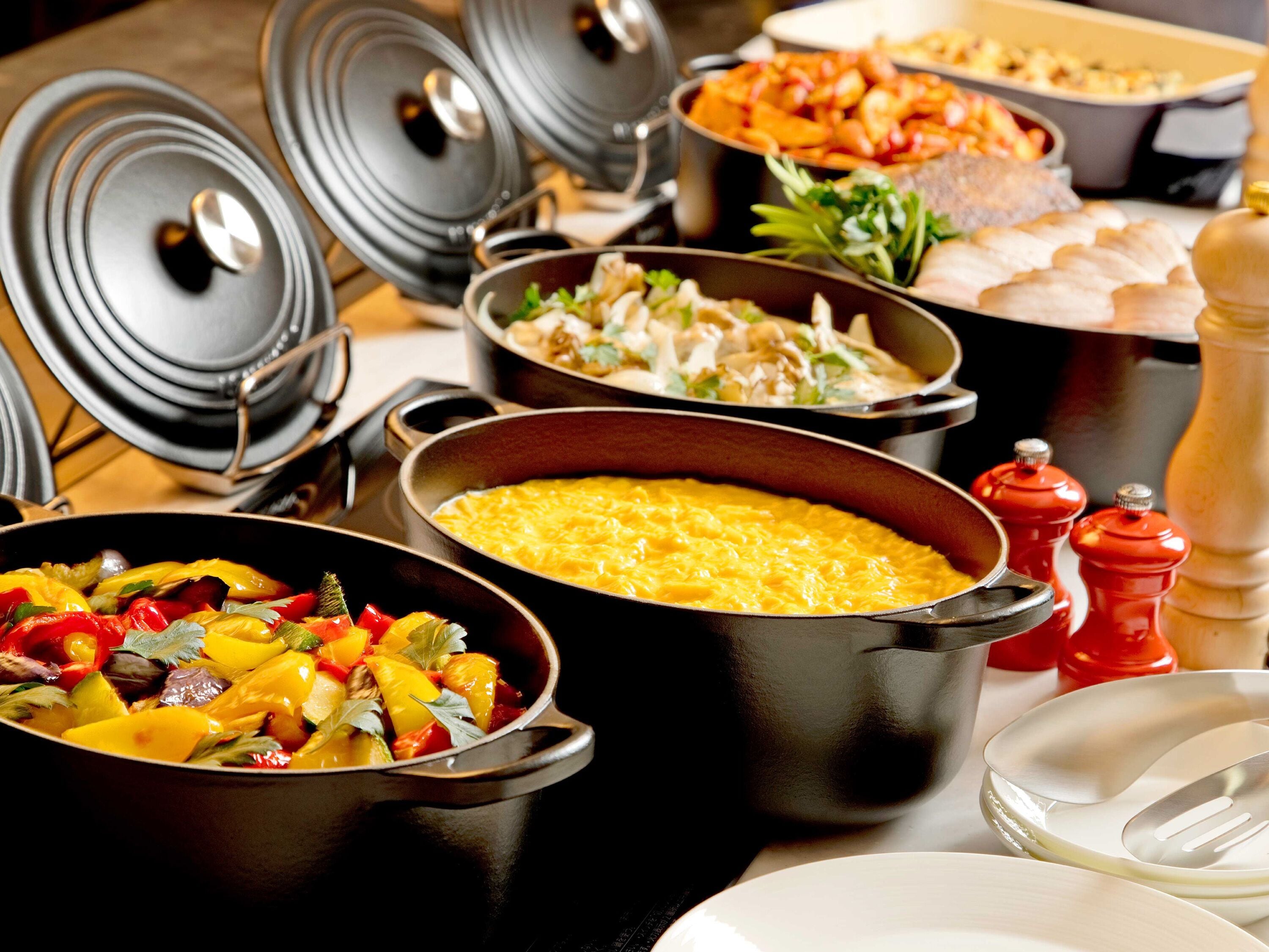 A variety of dishes in pots and bowls, suggesting a buffet setting.