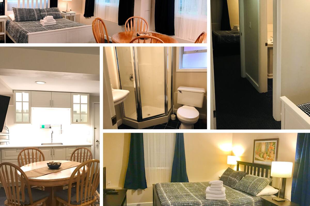 Habitación de hotel con cama, escritorio, silla, baño con ducha y zona de comedor con mesa y sillas.