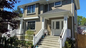 A two-story house with a front porch, a staircase, and a mailbox. - Windsor Guest House (Vancouver)