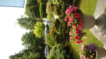 Un jardín bien cuidado con varios macizos de flores y setos ordenados.
