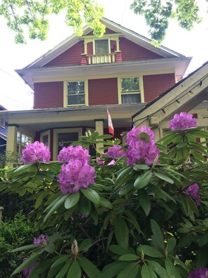 A two-story house with a porch and a flag. - Douglas Guest House (Vancouver)