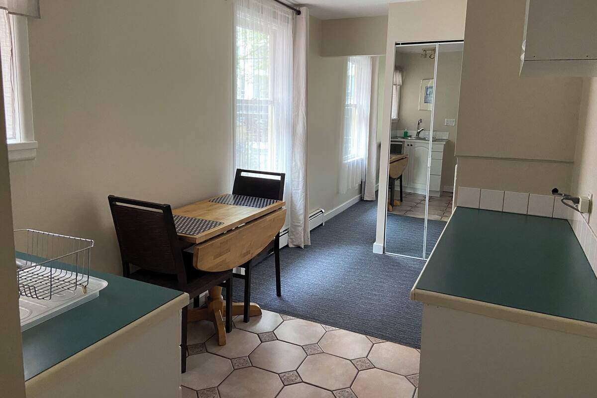 A compact kitchen with a dining area, a small kitchenette, and a view of the adjacent bathroom.