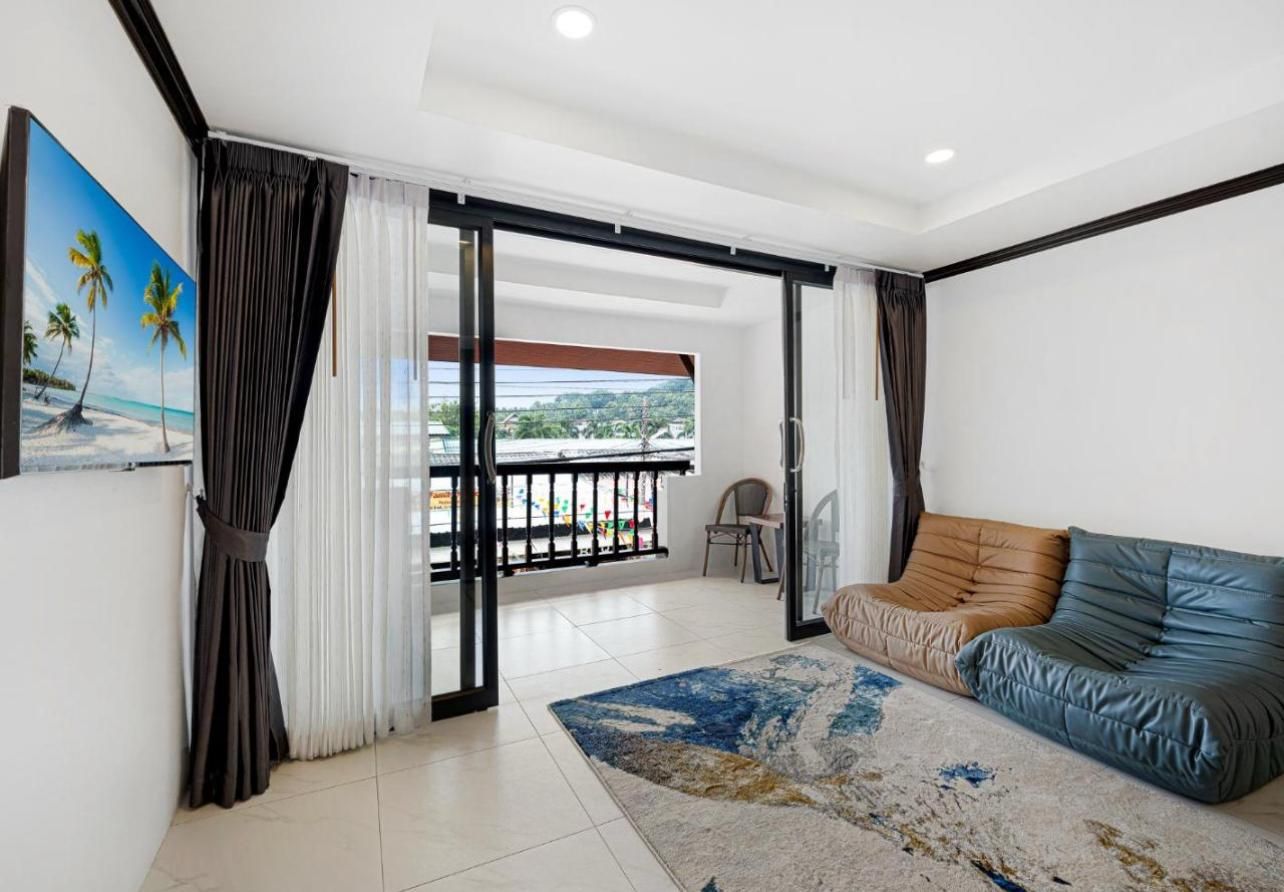 A modern living room with a sofa, a rug, and a painting of a beach scene.