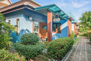 A modern house with a blue facade, wooden accents, and a covered porch. - My Village Lamai (Koh Samui)