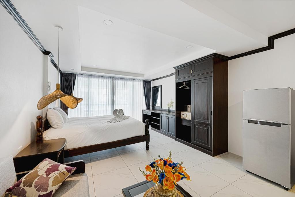 A modern hotel room with a bed, bedside table, lamp, and a decorative vase.