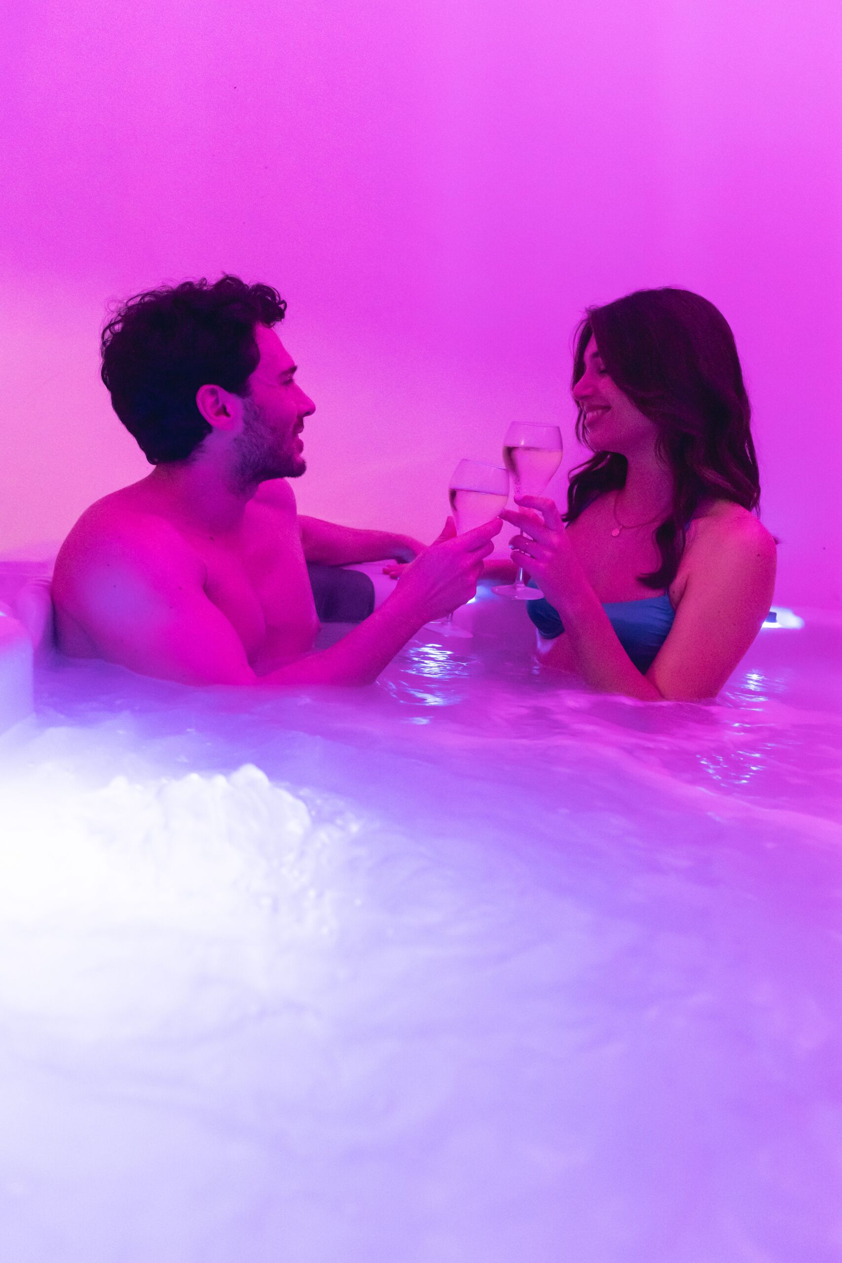 Zwei Personen in einer Badewanne mit rosafarbenem Licht.