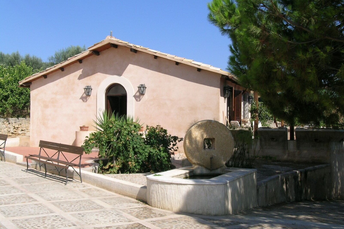 A building with a simple, rustic architectural style, featuring a flat roof and a small arched entrance.