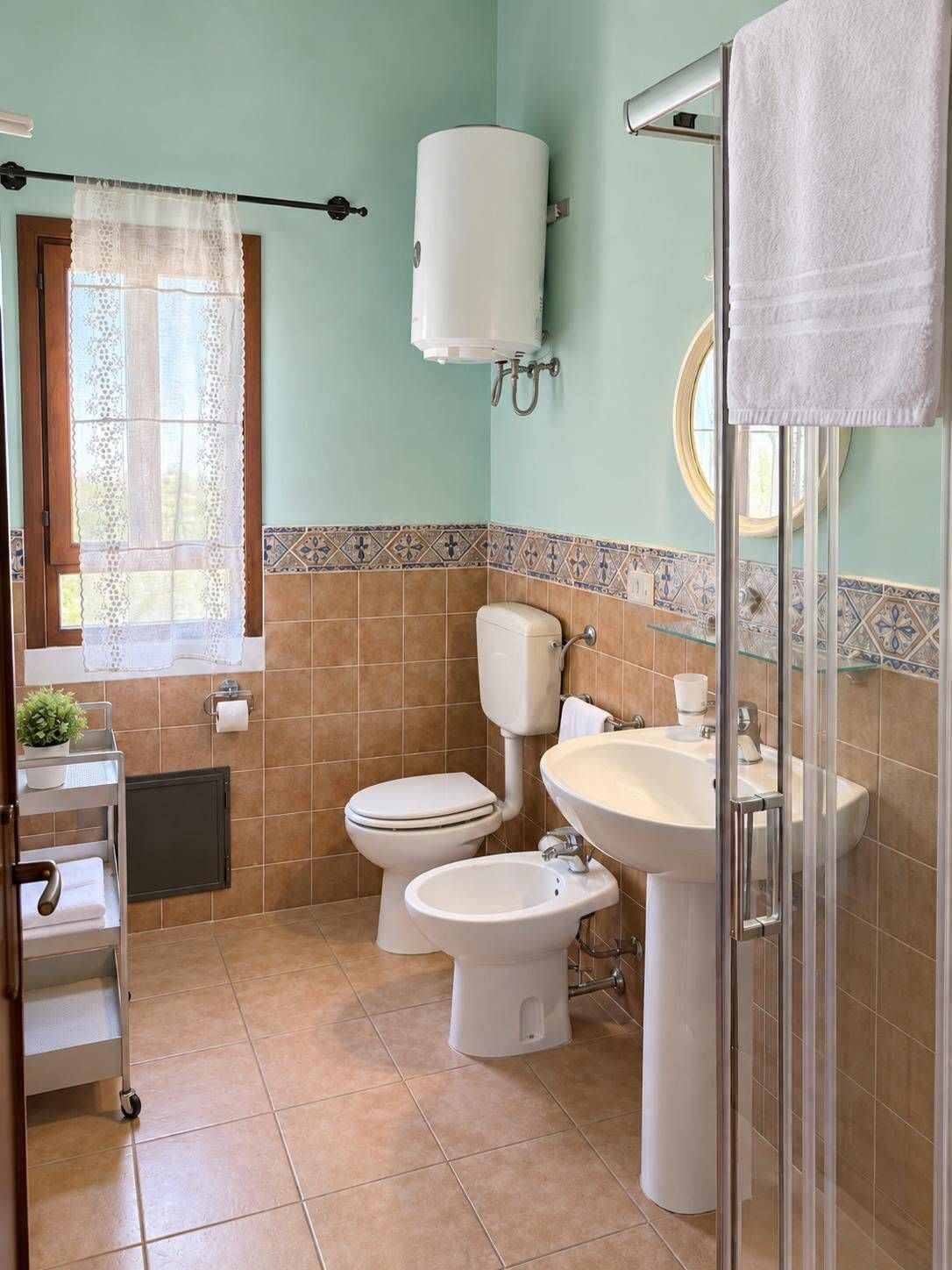 Un bagno con WC, bidet, lavandino e zona doccia.