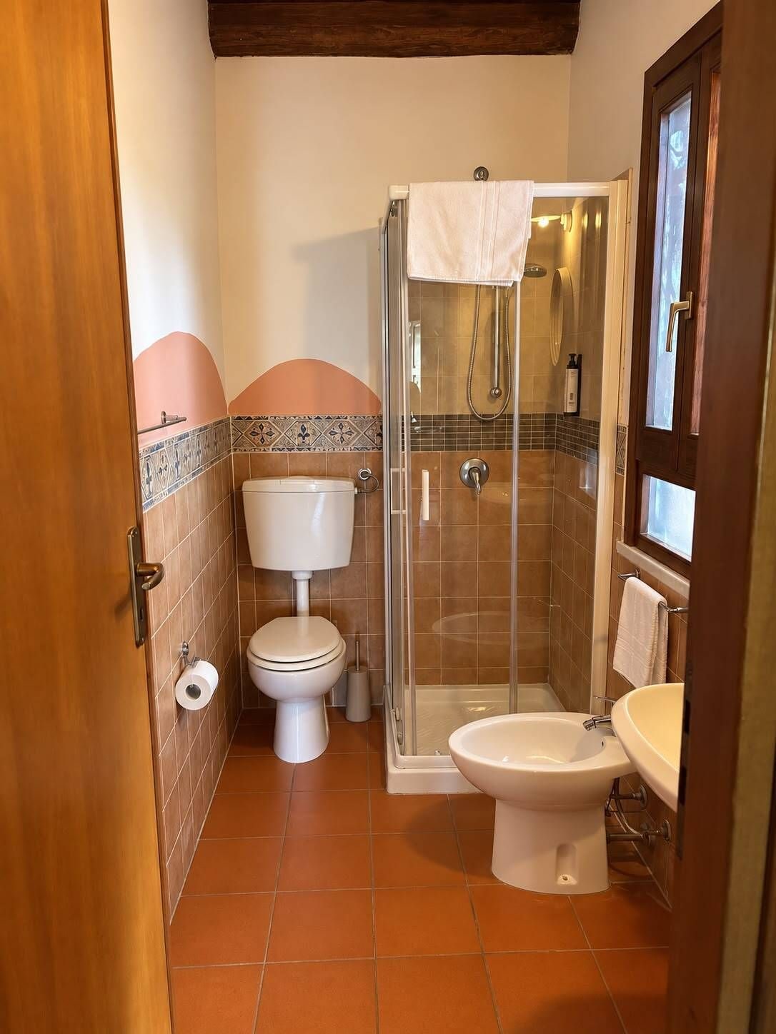 A bathroom with a toilet, bidet, and shower stall.
