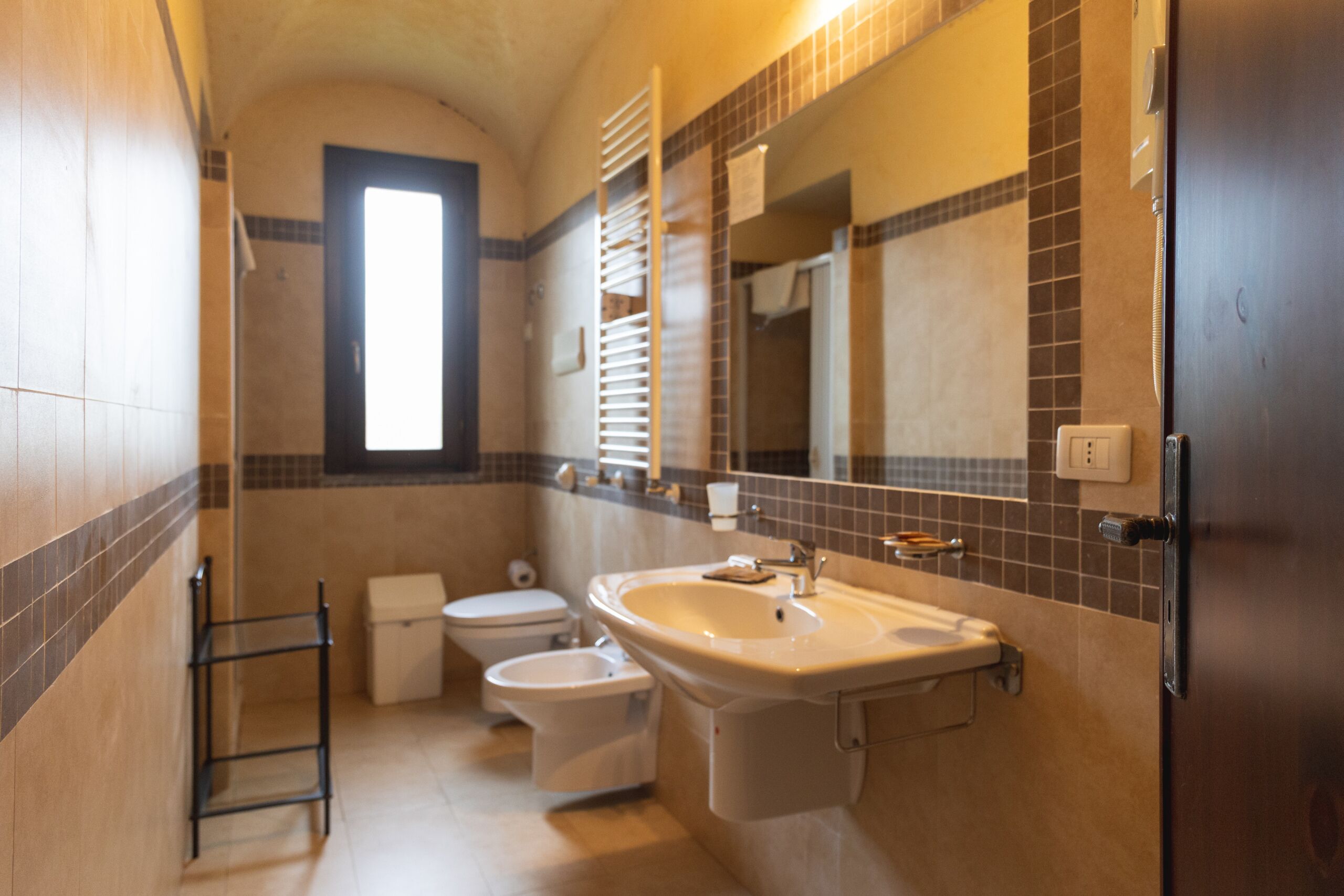 Une salle de bain équipée d’un lavabo, de toilettes, d’un bidet et d’un porte-serviettes.