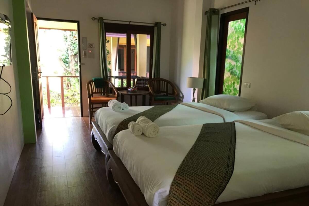 Une chambre d’hôtel avec un grand lit, une chaise, une table et une vue sur l’extérieur.