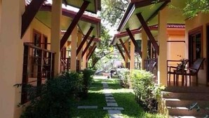 A corridor with a covered walkway, stone steps, and greenery. - Green Villa (Koh Samui)