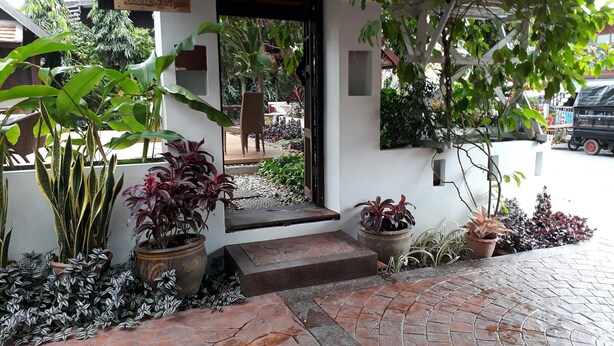 A building with a sign indicating operating hours. - Wiriya House (Chiang Mai)