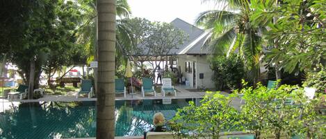 Ein Poolbereich mit Liegestühlen und einer überdachten Sitzgelegenheit.