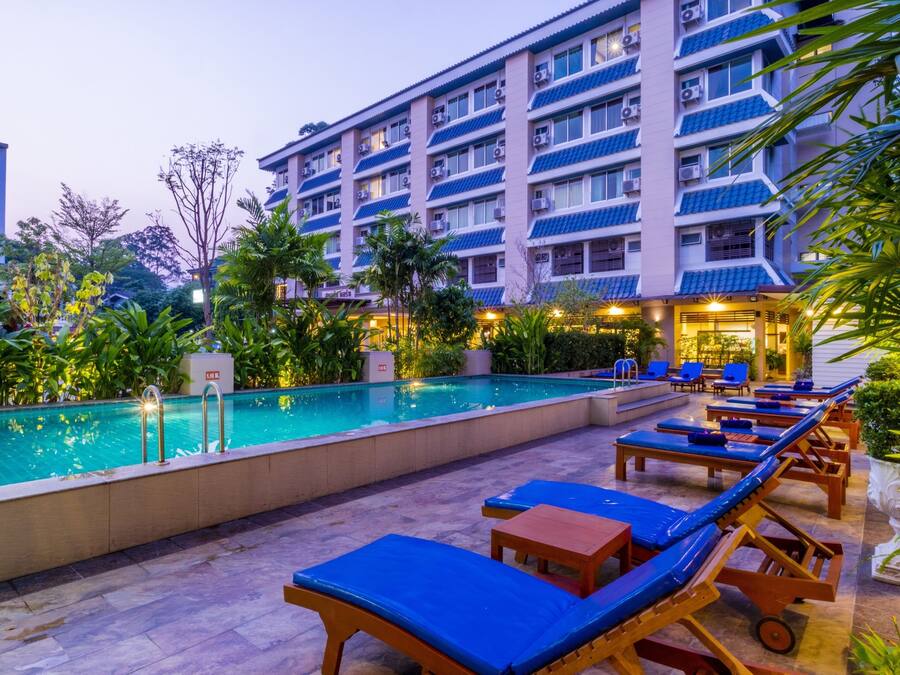 Uma área de piscina de hotel com espreguiçadeiras e uma piscina.