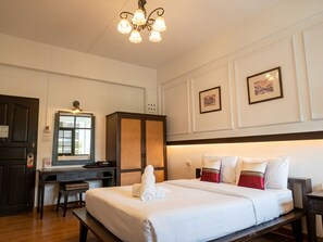 A hotel room with a bed, desk, wardrobe, and a chandelier. - Sakulchai Place Hotel (Chiang Mai)
